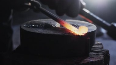 Demirci Forge içinde çekiç sıcak Metal örs üzerinde atıyor.