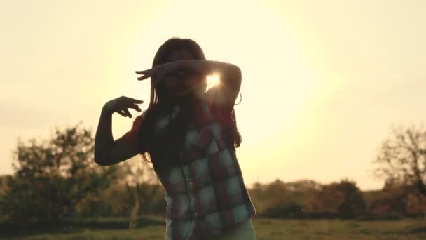 Силуэт девушки, танцующей на закате — стоковое видео