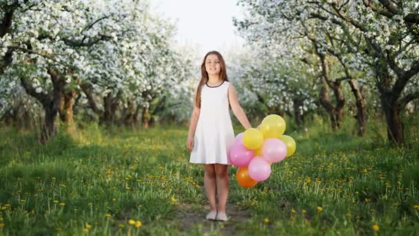 Retrato de una niña en un huerto de manzanas en flor — Vídeo de stock