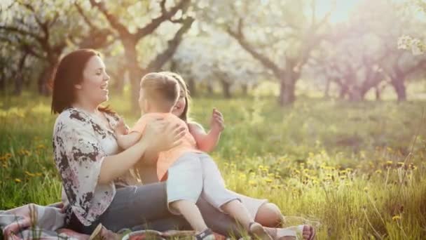 Hermosa madre y su pequeña hija e hijo al aire libre — Vídeos de Stock