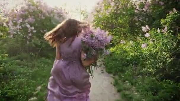 A menina corre junto com um buquê de lilases — Vídeo de Stock