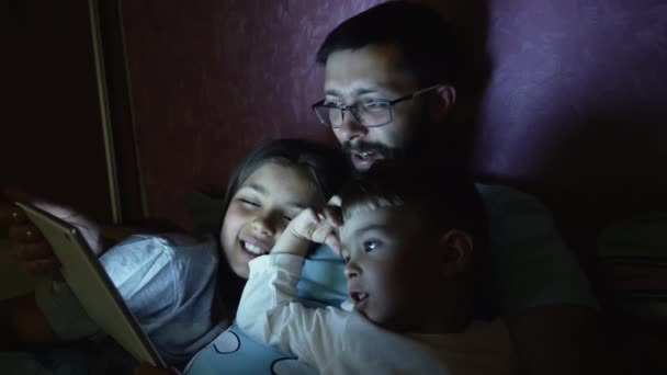 Père avec de petits enfants surfant sur tablette avant de dormir — Video