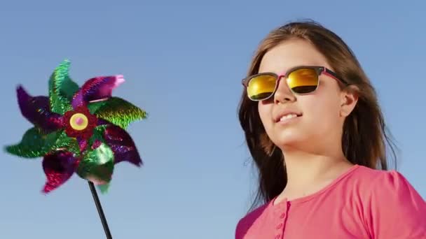 Schönes Mädchen mit Windmühlenspielzeug — Stockvideo