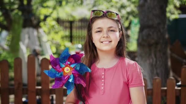 Menina pré-adolescente com brinquedo de moinho de vento — Vídeo de Stock