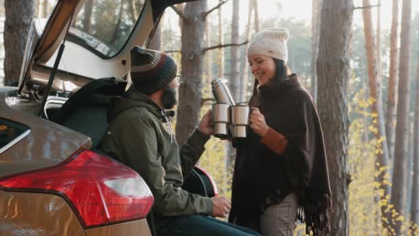 Пара пьет кофе возле машины в лесу — стоковое видео