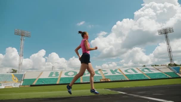 Jovem atlético menina corre na pista de corrida — Vídeo de Stock