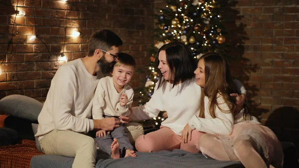 Glad familj i sovrummet på julafton Stockbild