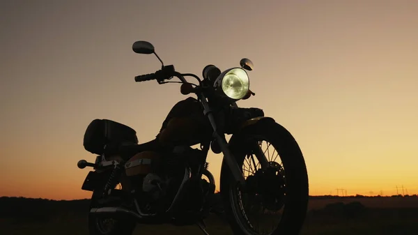 Silhuett vid solnedgången av en motorcykel Royaltyfria Stockbilder