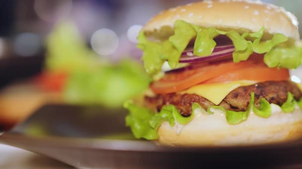 Szaftos hamburger egy tányéron, közelkép. — Stock videók