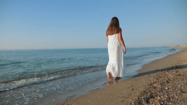 A barefoot girl walks along the sea coast — Stock Video