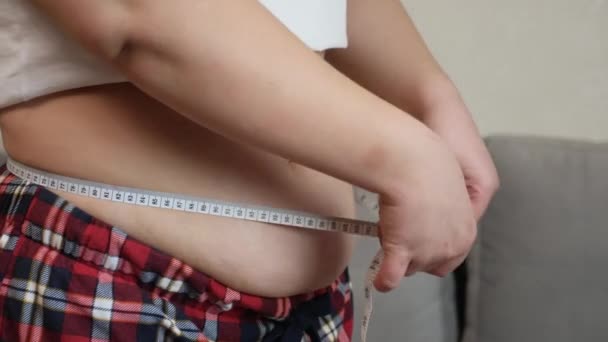 Übergewichtiges, dickes Mädchen, das seinen Bauch misst — Stockvideo