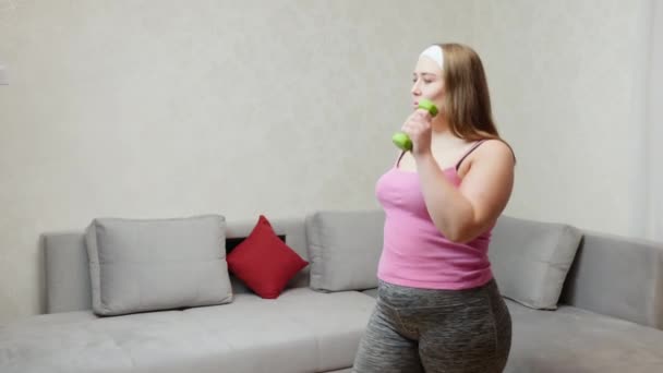 Buclatý žena dělá cvičení podle činka v pokoji — Stock video