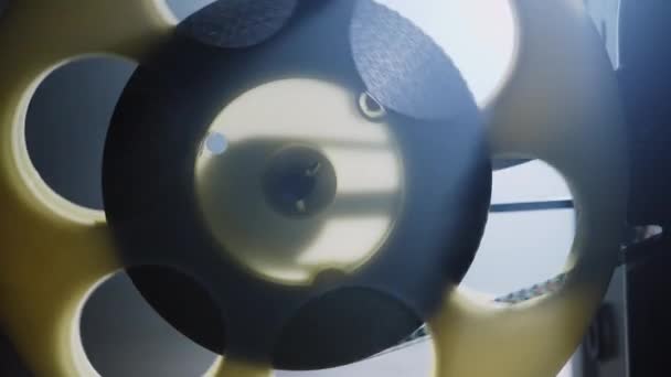 Bobine avec un film rotatif et des rayons lumineux. Vieux projecteur de film