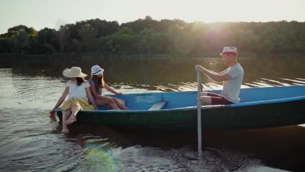 Jonge familie vaart in een houten boot — Stockvideo