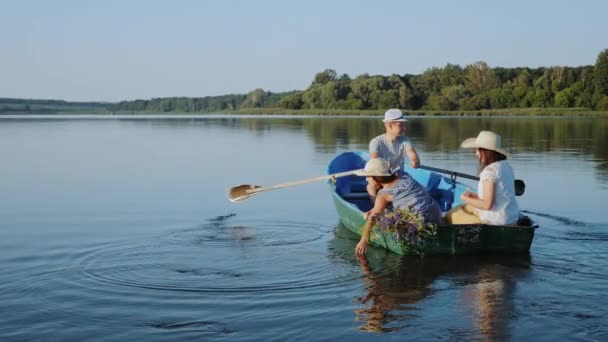 Jonge familie vaart in een houten boot — Stockvideo