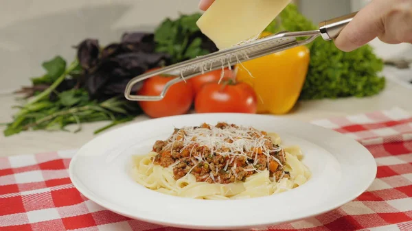 Chef grinds parmesan cheese into a finished dish — Stock Photo, Image