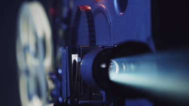 Eski film projektörü bir film gösteriyor, yakın plan.