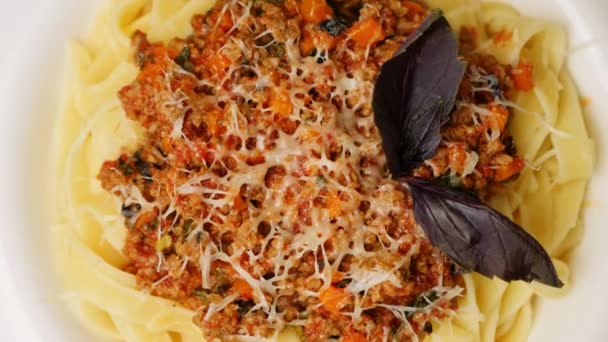 Roterande vit platta med pasta bolognes, närbild — Stockvideo