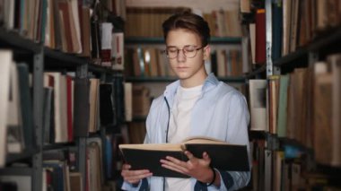 Portrait of a teen boy with a book in the library