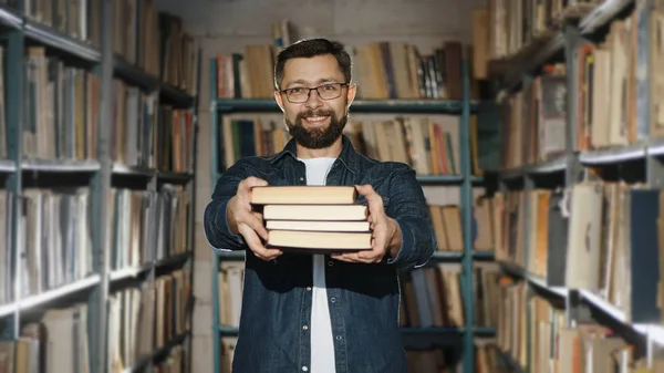 A bearded man in glasses suggests reading several books
