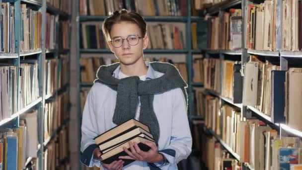 Retrato del guapo adolescente en la biblioteca — Vídeo de stock