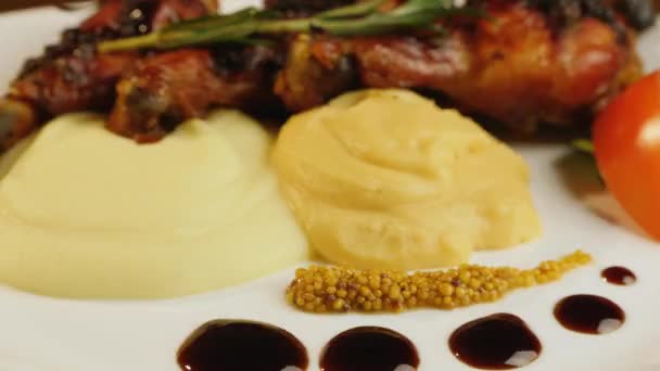 Rotating plates with grilled chicken legs with mashed potatoes — Stockvideo