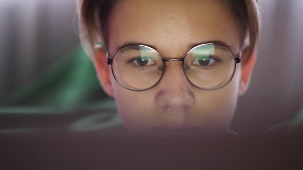 Хлопчик-підліток дивиться на екран ноутбука, крупним планом — стокове відео