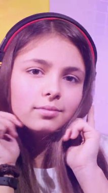 Genç kız kulaklıkla müzik dinliyor.