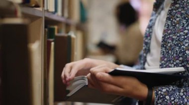 Kitap okuyan genç adam, yakın çekim eller.