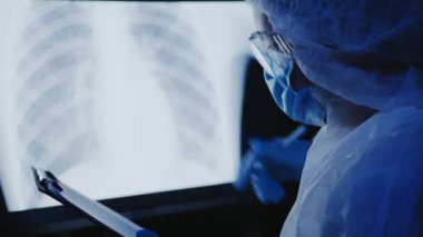 Doktor akciğer zatürreesinin röntgen fotoğrafı üzerinde çalışıyor.
