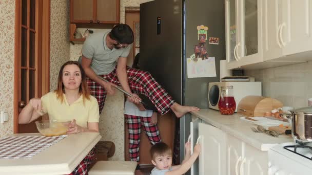 Забавная семья в хаосе на кухне во время карантина — стоковое видео