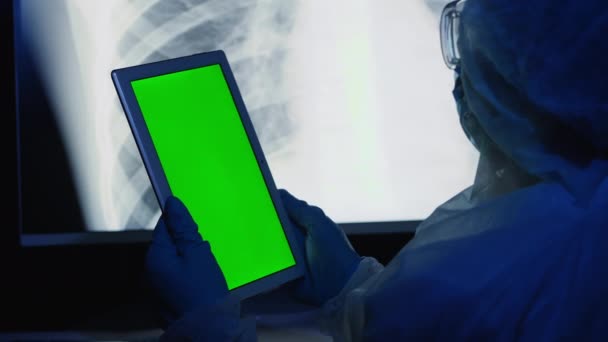 Koruyucu giysili doktor yeşil ekranlı bir tablet kullanıyor. — Stok video