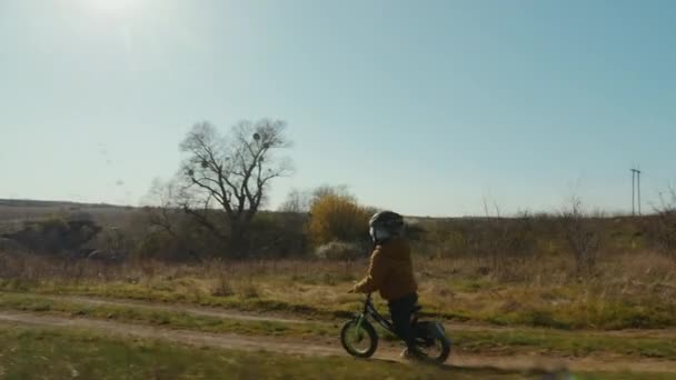 O menino voa sobre a roda de uma runbike, queda dura — Vídeo de Stock