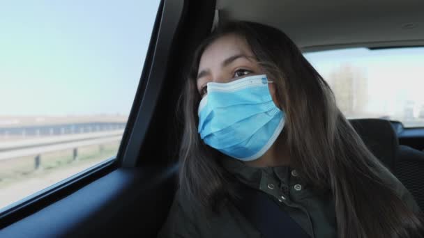 Chica en una máscara médica cabalga en un coche — Vídeo de stock