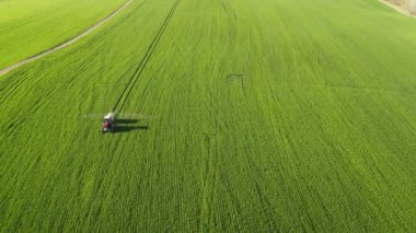 Bir traktörün kış buğdayını püskürttüğü hava manzarası