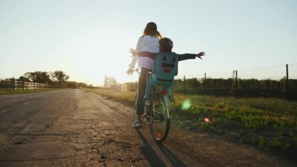 Mamma con il suo piccolo figlio stanno andando in bicicletta sulla strada — Video Stock