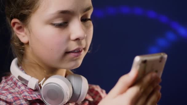Девочка-подросток смотрит на экран смартфона, крупным планом — стоковое видео