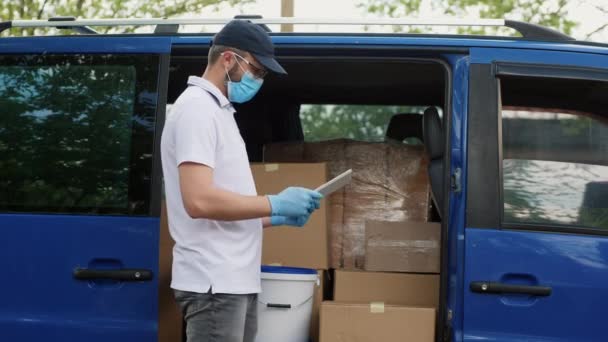 Uomo di consegna con un tablet controlla il suo numero di carichi — Video Stock