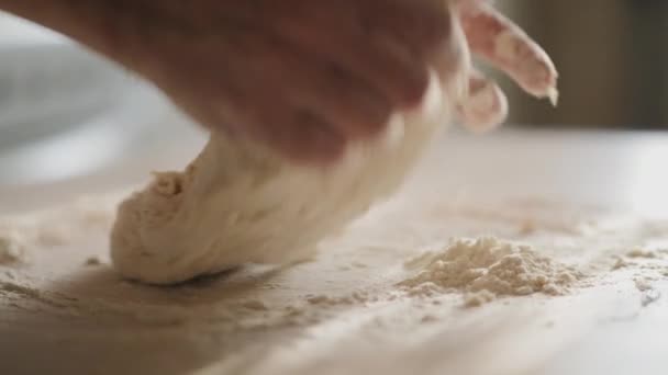 Женские руки смешивают тесто в муке на столе — стоковое видео