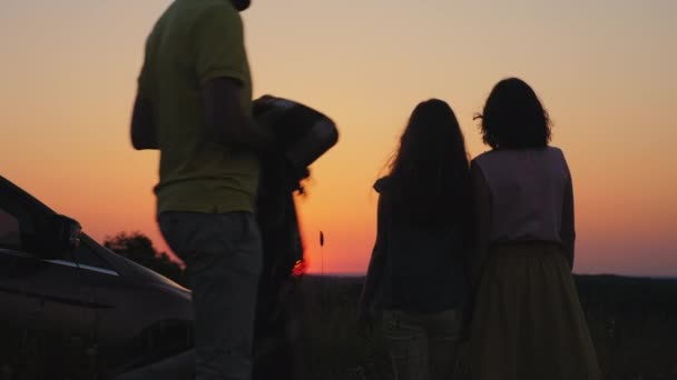 Gelukkig familie knuffelen kijken naar de zonsondergang — Stockvideo