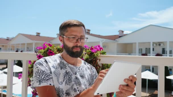 Бородатий хлопець у відпустці працює на планшеті — стокове відео