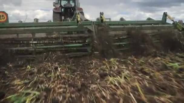 Een roterende cultivator op een tractor in het werk op het veld, close-up — Stockvideo