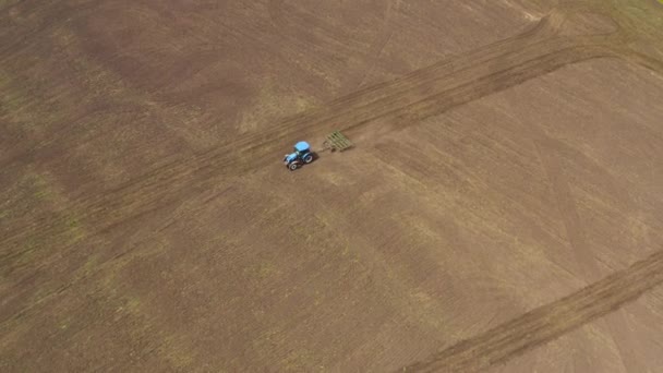 Flygfoto av en traktor med en kultivator som arbetar i fält — Stockvideo