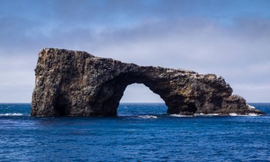 Mavi bir gökyüzü ile Okyanusu üzerinde kemer kaya