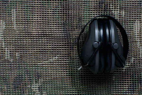 Ear protection headphones lies on the multicam background