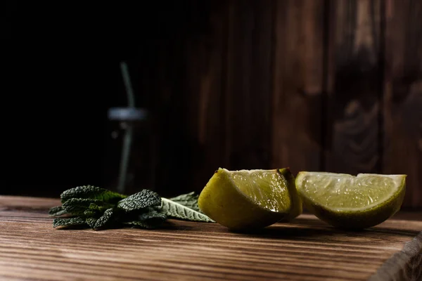 Limette und Minze liegen auf einem Holzuntergrund. — Stockfoto