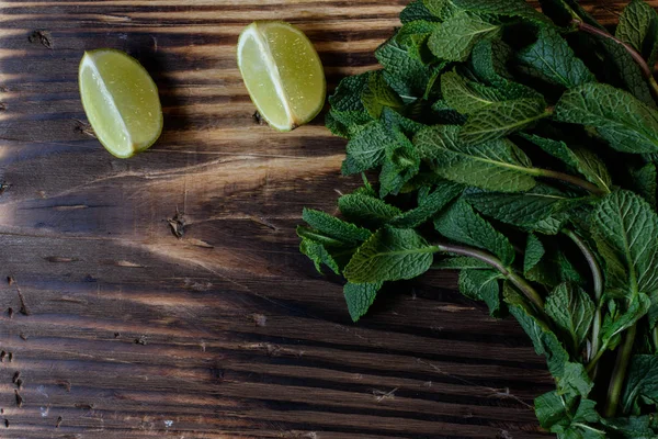 Demet taze nane ve limon dilim ahşap arka plan üzerinde.