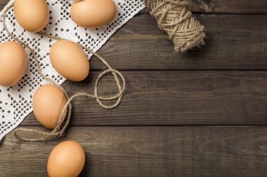 Ham, tavuk yumurtası koyu ahşap mutfak masasında.