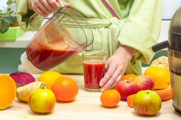 A woman is making freshly squeezed juice on a juicer