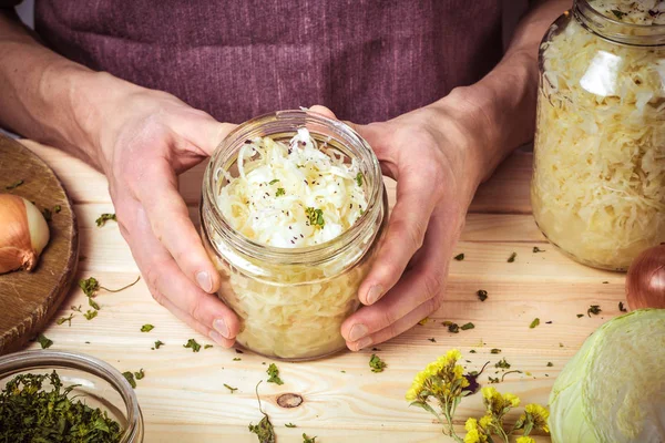 Cabbage sauerkraut in glass jars, hands of the cook. — Stock Image Cabbage Sauerkraut Glass Jars Hands Cook Royalty Free Stock Images